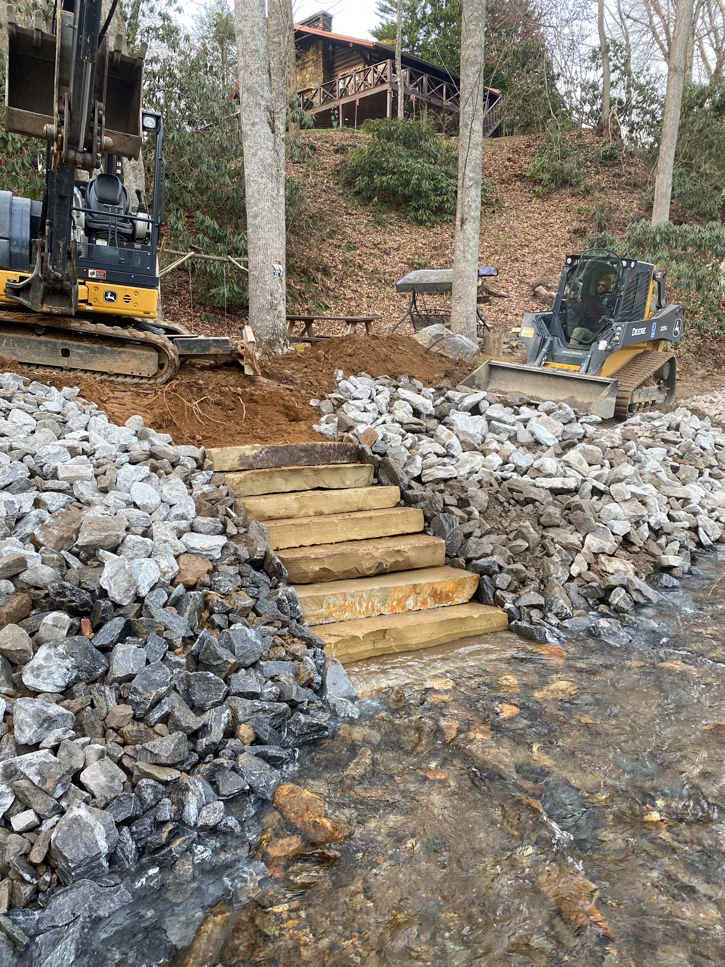 Construction equipment building wooden steps at creek