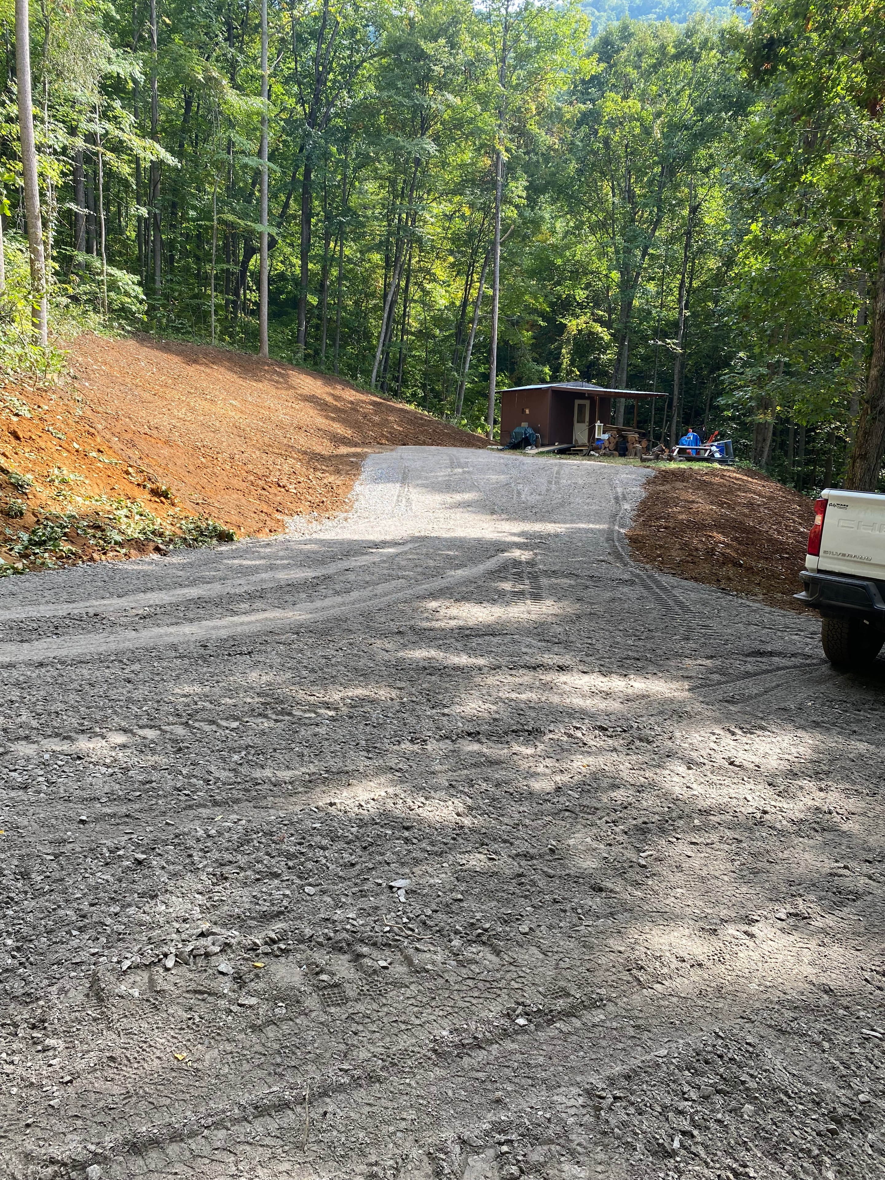 Gravel driveway through forest cabin clearing