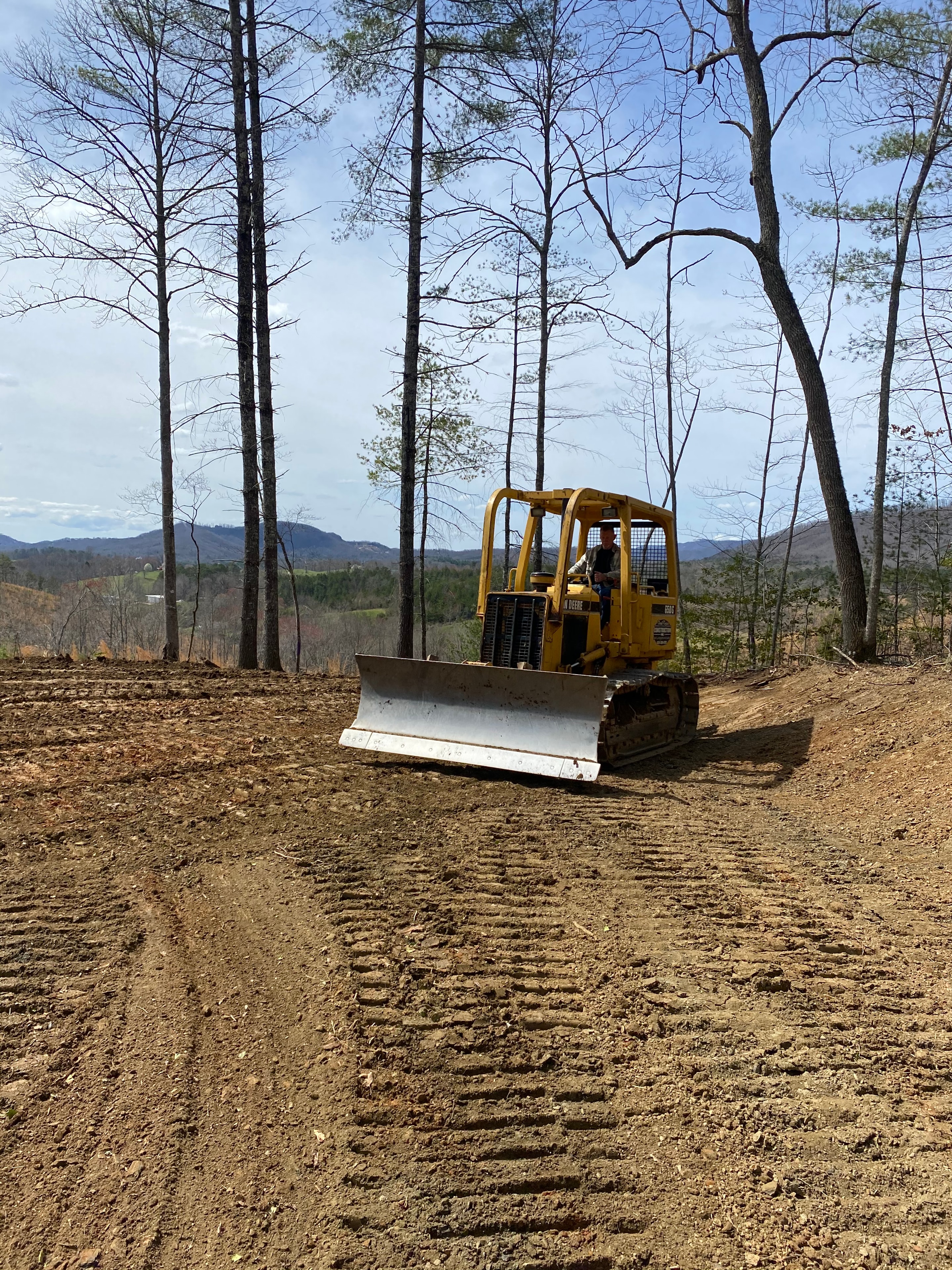 Yellow bulldozer clearing forest land