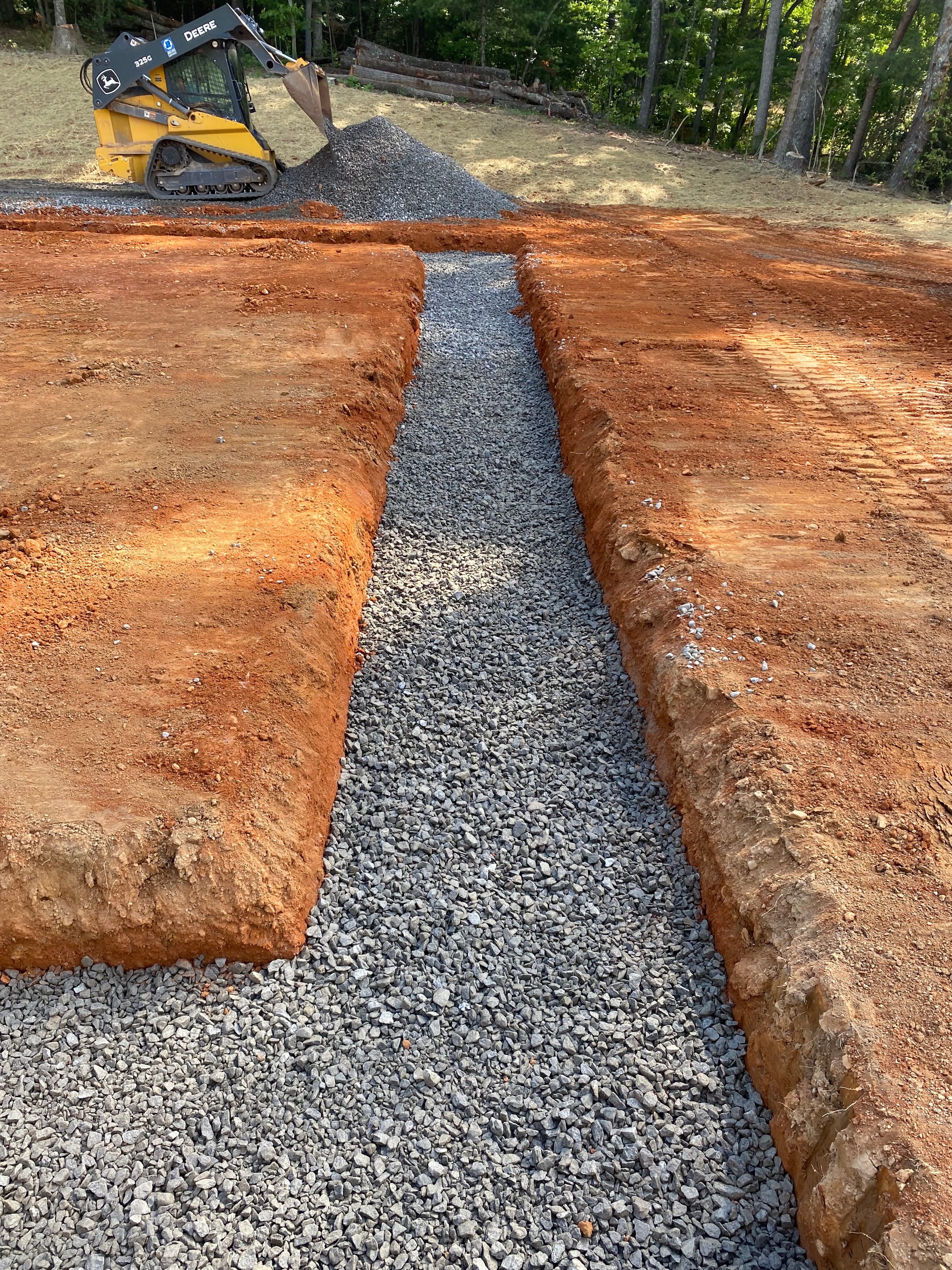 Gravel trench excavation with skid steer loader